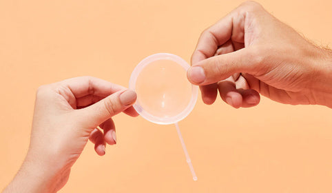 Two Hands Holding a Menstrual Disc