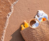 Sisal Bag Containing Beach Items on the Sand Next to the Sea