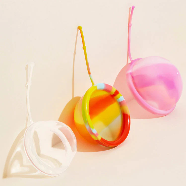 Three different sized menstrual discs in three different colors